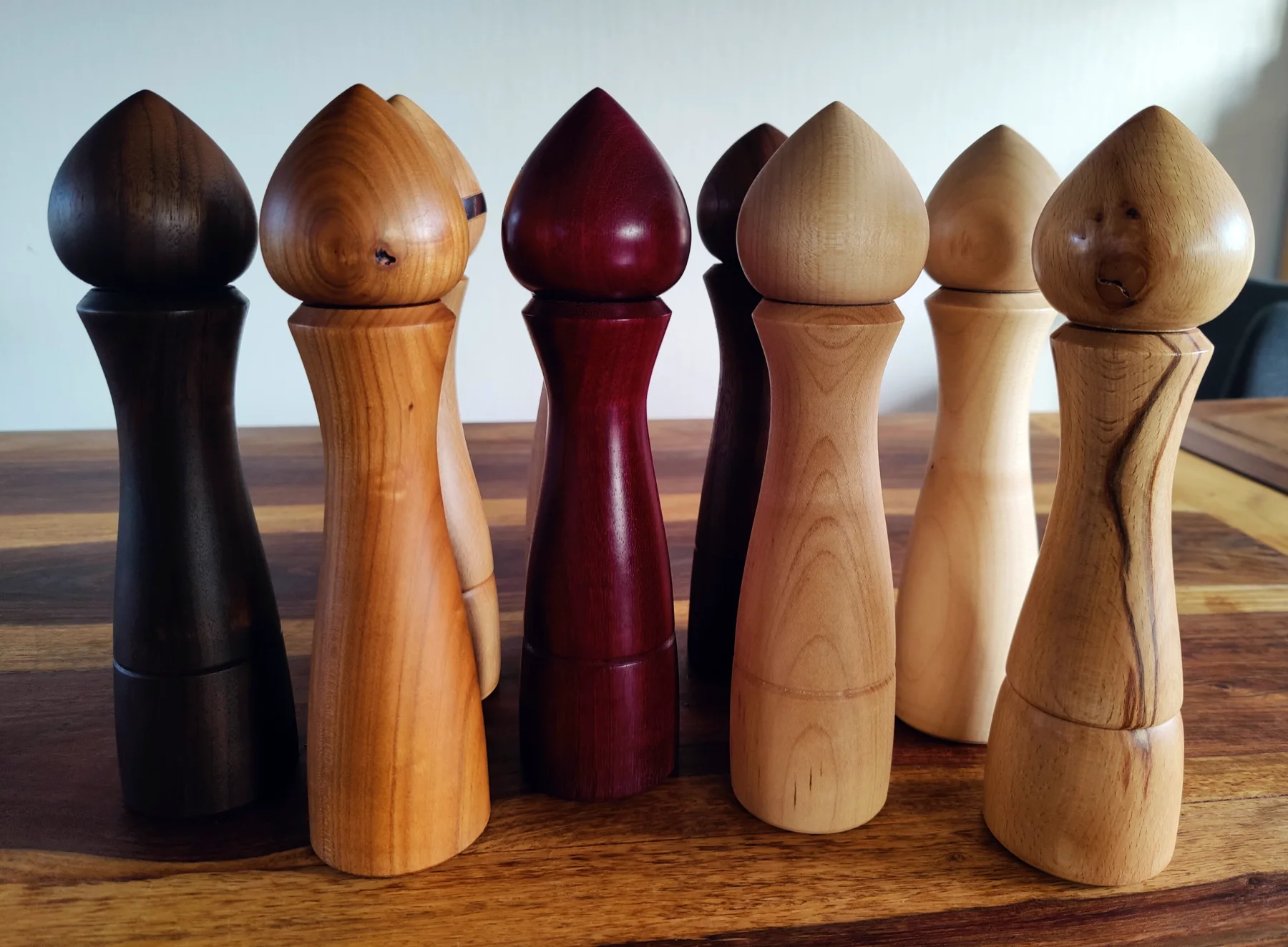 Many pepper grinders on a table