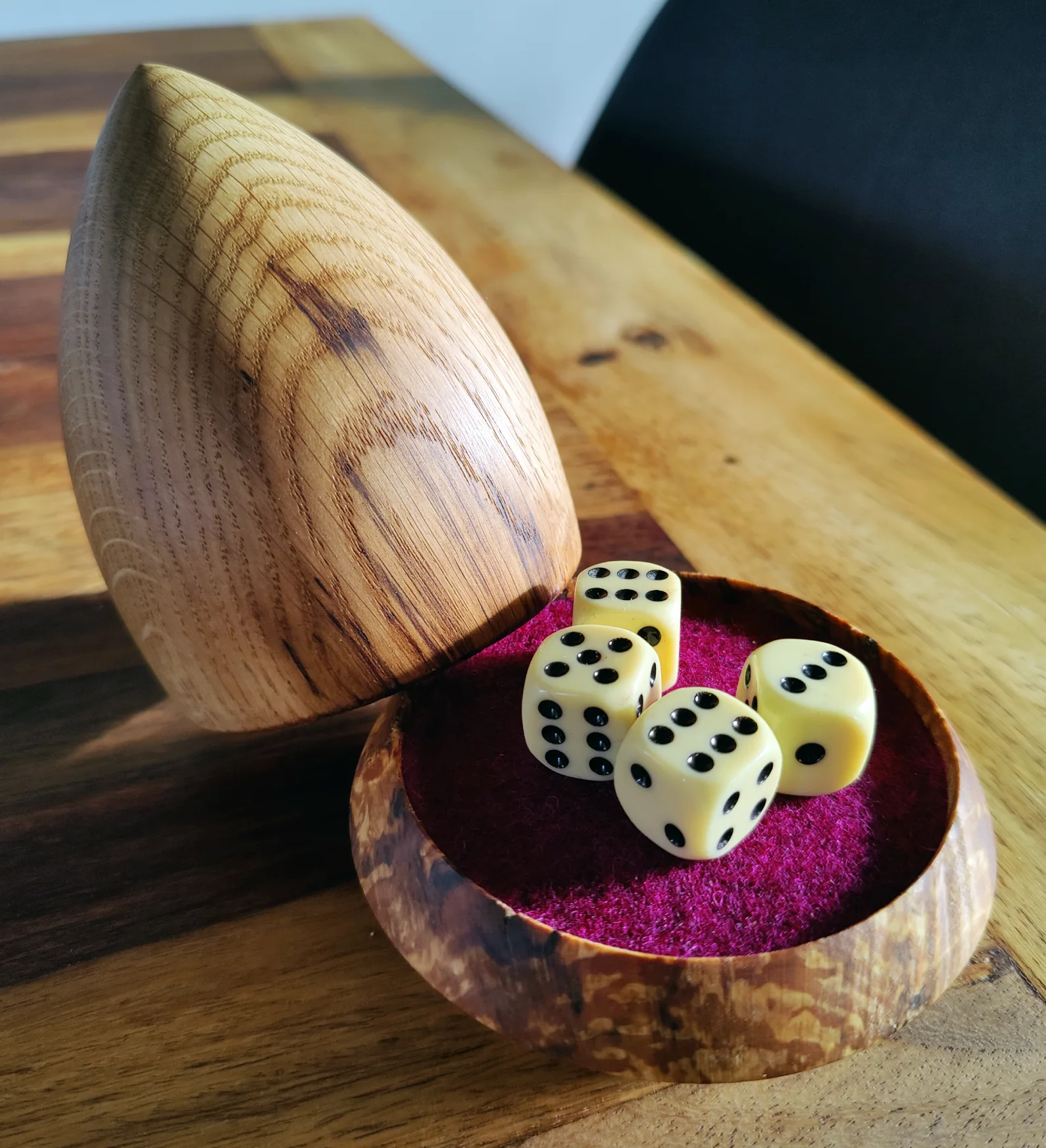 raffle cup. the lid is leaning on the base revealing 4 dice